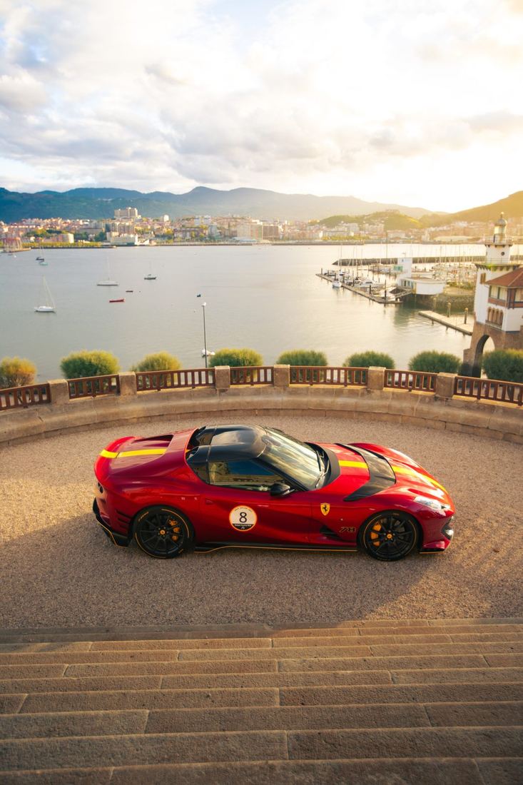 Rode Ferrari 812 Competizione A op een terras boven een jachthaven