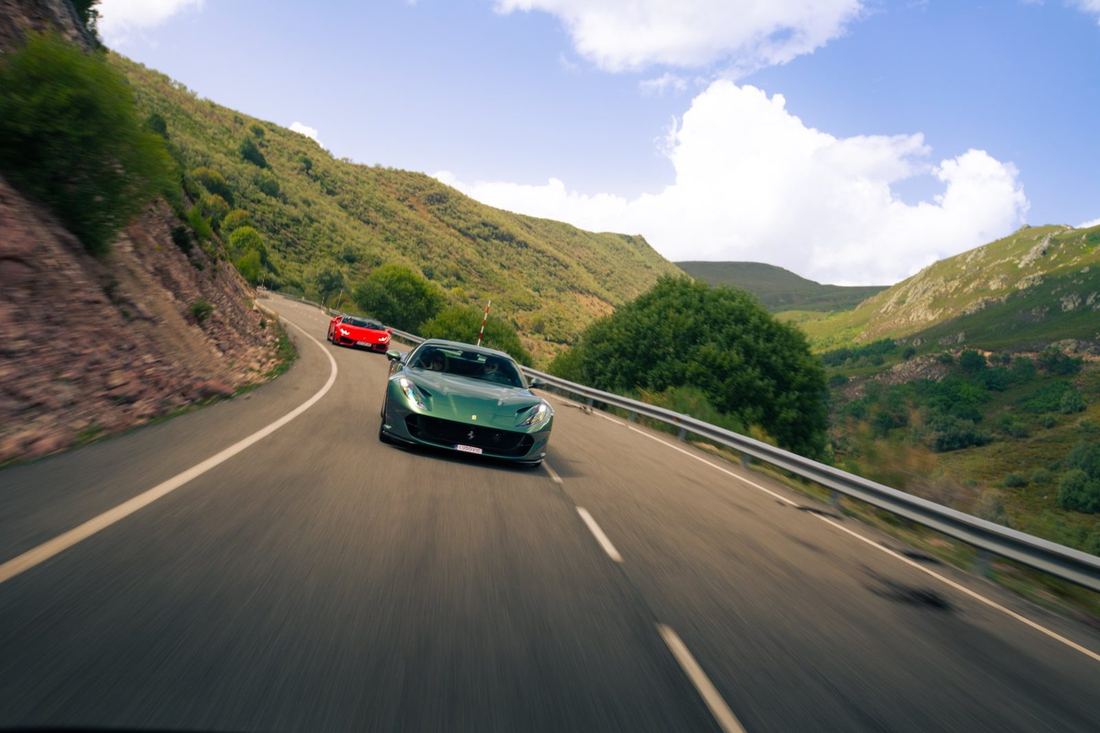Groene Ferrari en rode Lamborghini op een bergweg
