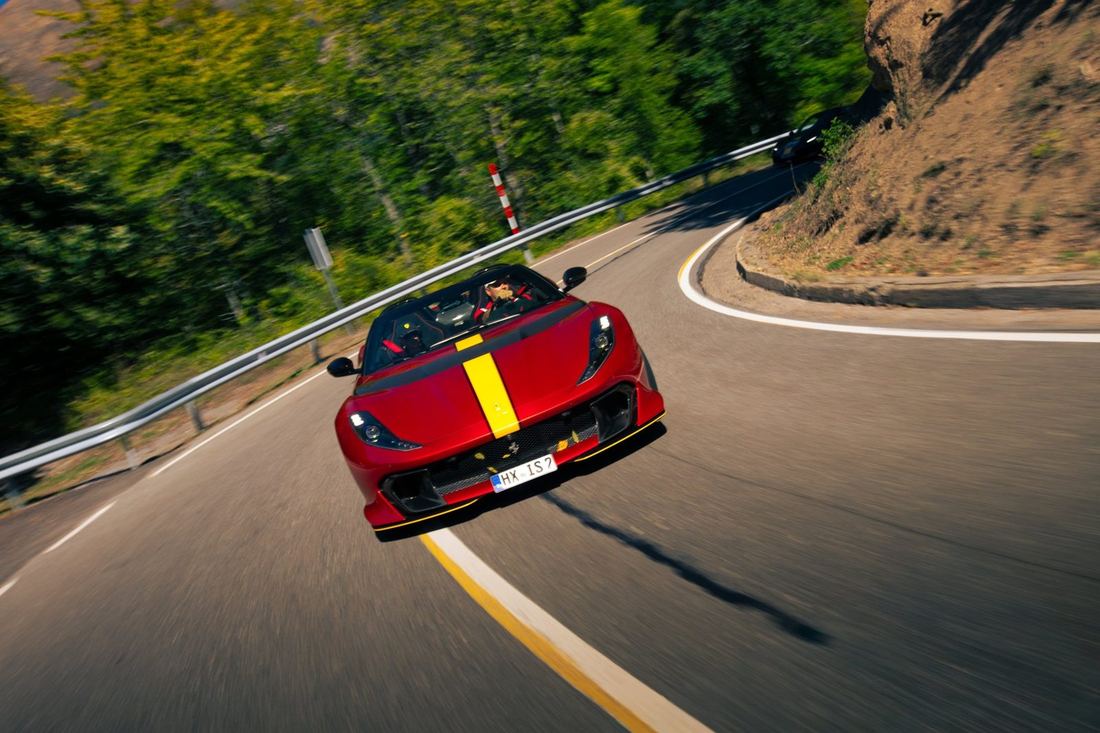 Rode Ferrari met gele streep in een haarspeldbocht