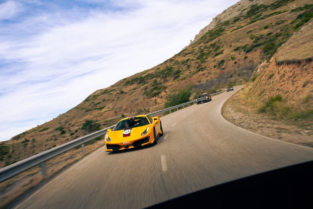 Gele Ferrari voorop een groep op een bergweg
