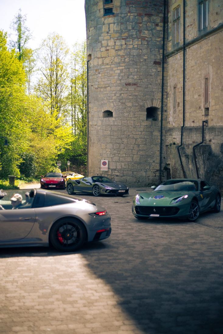 Ferrari’s en een Porsche bij de toren van het kasteel