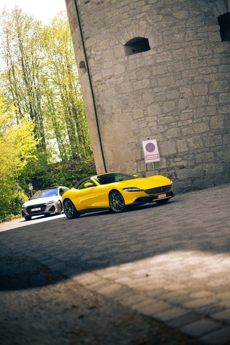 Gele Ferrari Roma Spider aan de voet van de toren