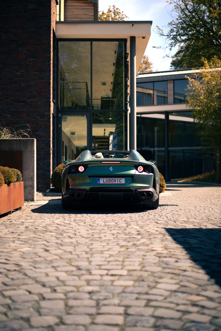 Groene Ferrari 812 GTS van achteren op de kasseien
