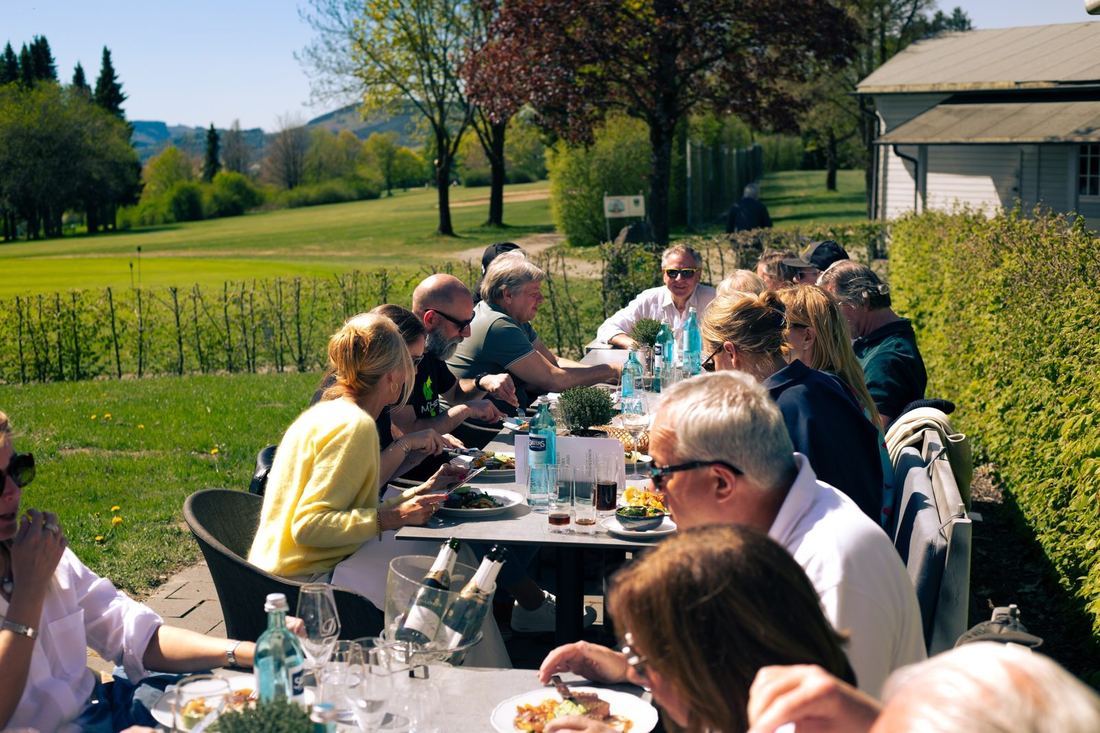 Lange tafel met deelnemers bij de lunch in de zon