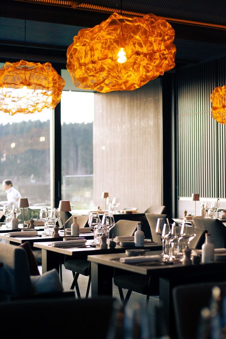 Gedekte tafels onder oranje lampen in het restaurant