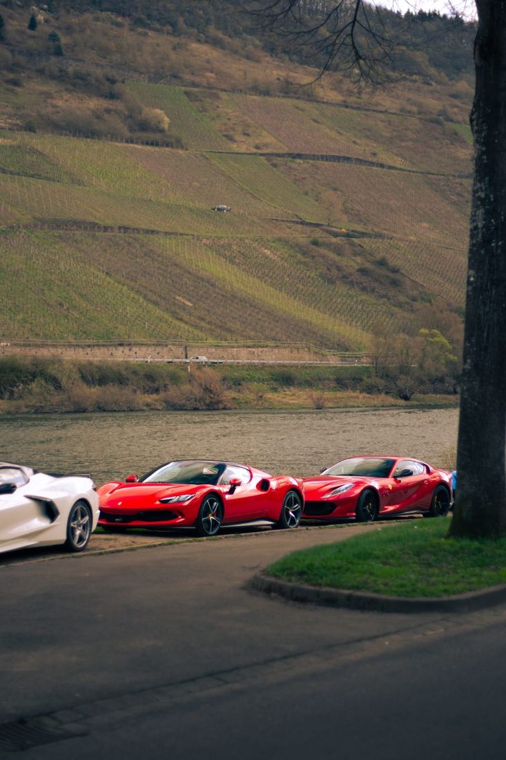 Twee rode Ferrari’s langs de Moezel met wijnbergen