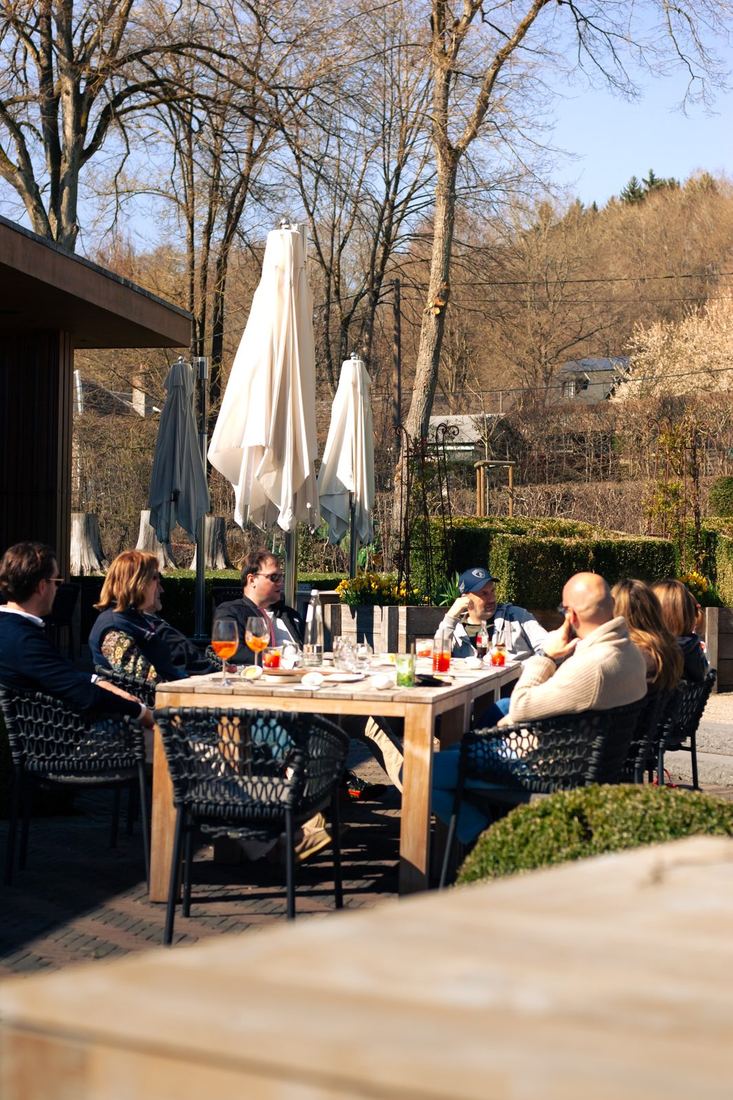 Deelnemers aan tafel op een zonnig terras