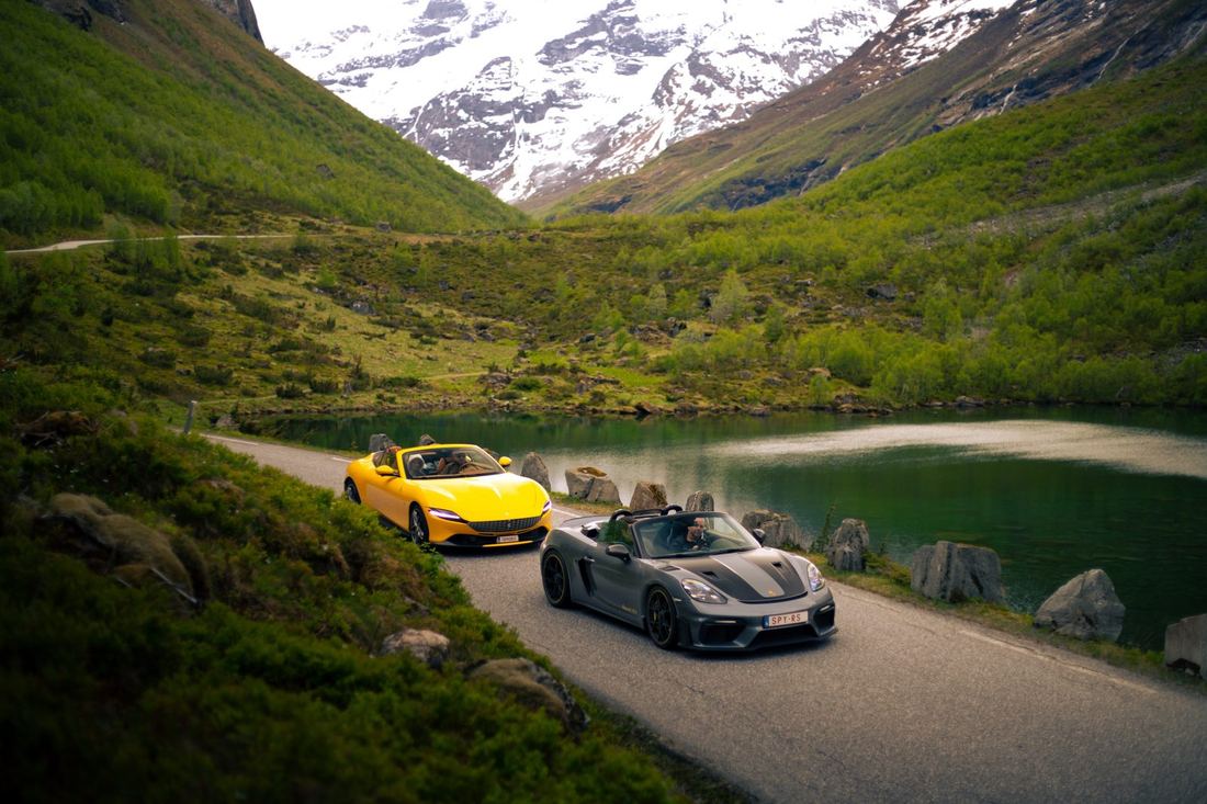 Gele Ferrari en Porsche Spyder op een smalle weg langs het meer