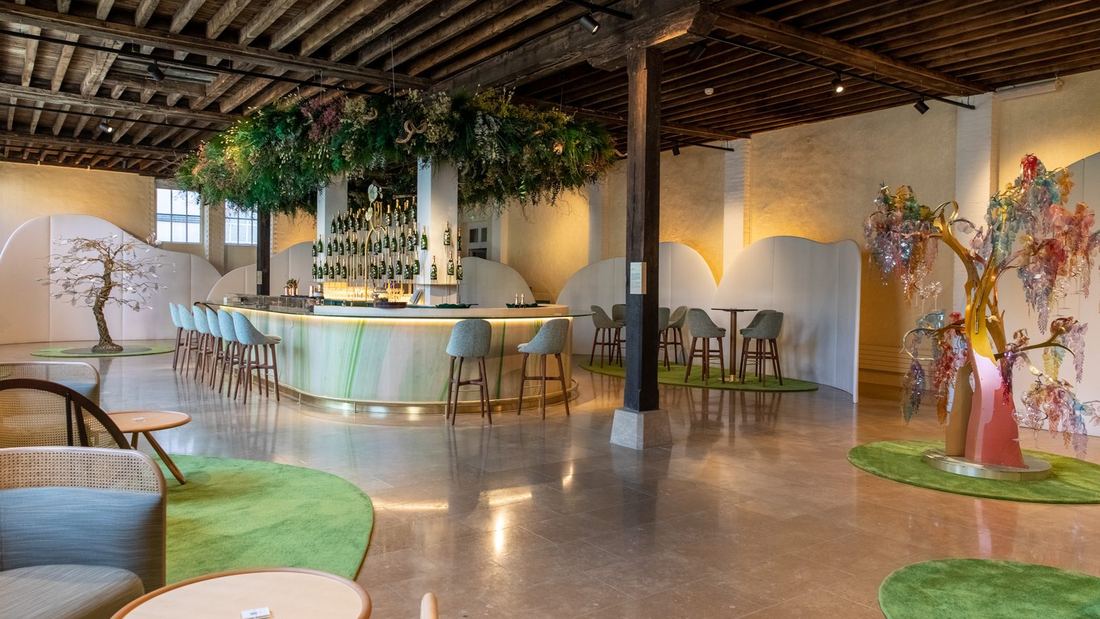 Bar van Perrier-Jouët met een groen bloemenplafond en kunstige bomen
