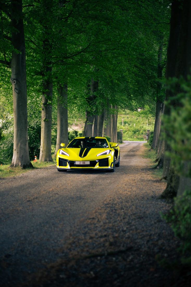 Gele Corvette in een bomenlaan