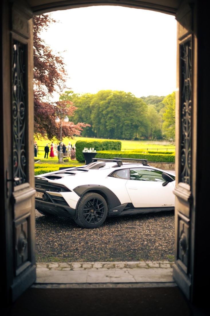 Witte Lamborghini gezien door de deur van het kasteel