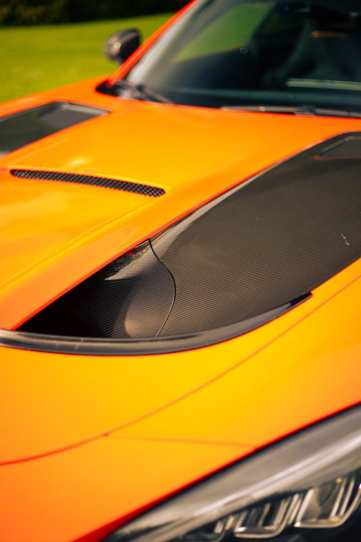 Detail van de motorkap van de oranje Mercedes-AMG