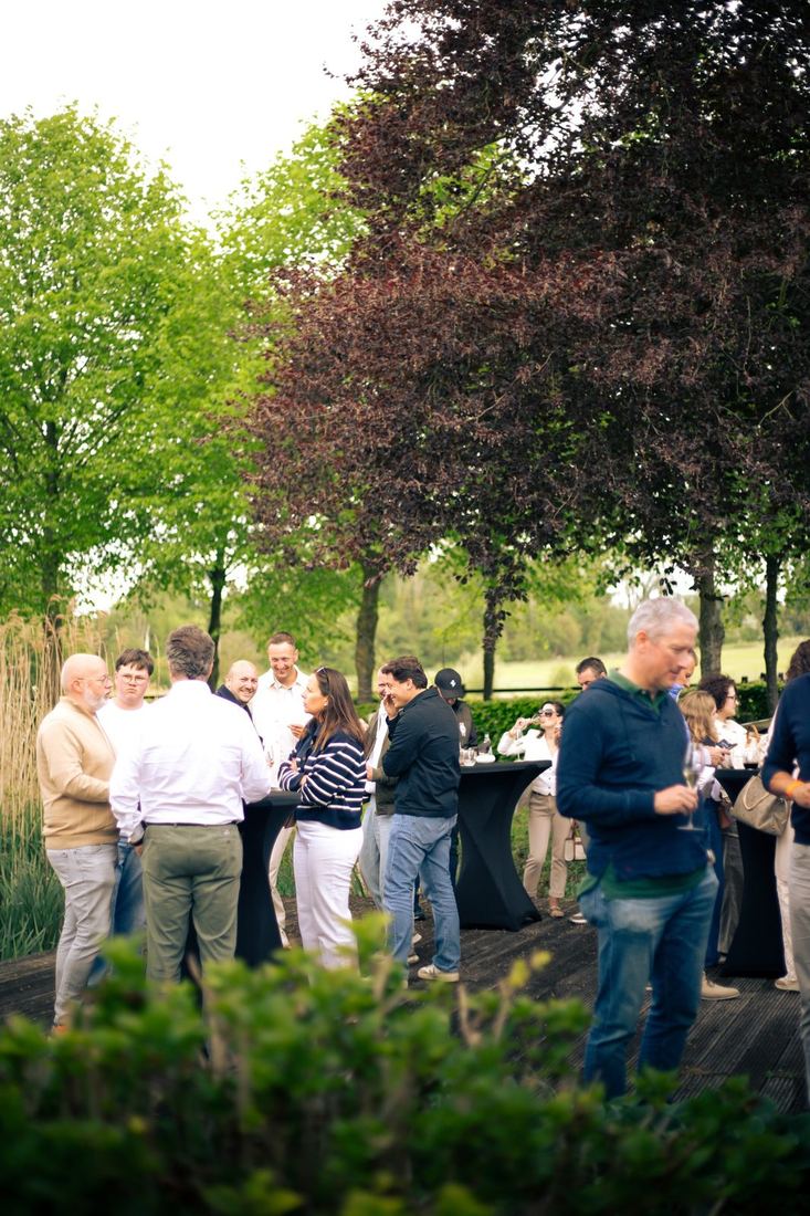 Deelnemers genieten van de apero in de tuin