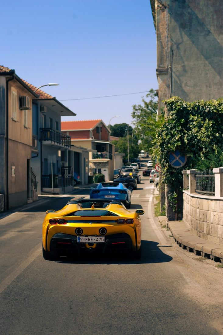 Gele Ferrari SF90 Spider voorop door een Kroatisch dorp