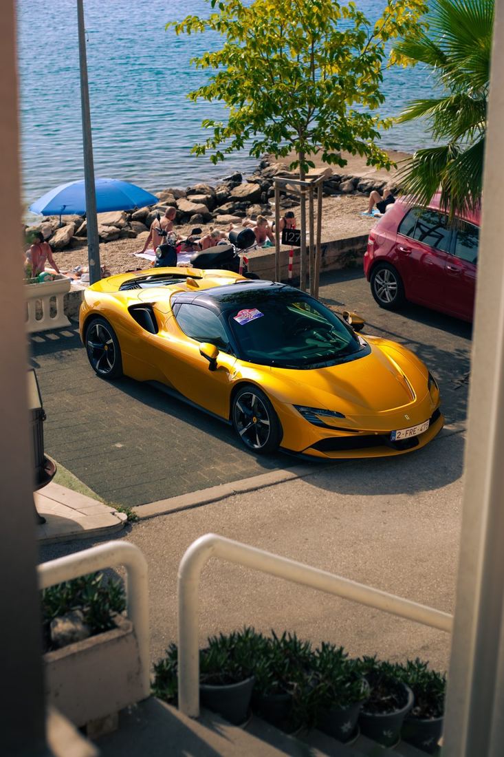 Gele Ferrari SF90 aan het strand