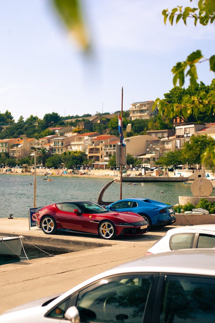 Ferrari 12Cilindri en blauwe 812 GTS aan de haven
