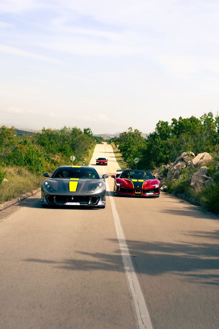 Grijze 812 Competizione en SF90 XX op een rechte weg