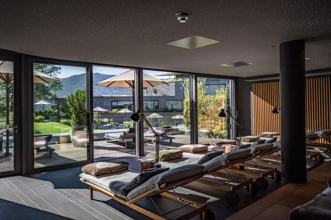 Relaxruimte van de spa met uitzicht op de tuin en de bergen